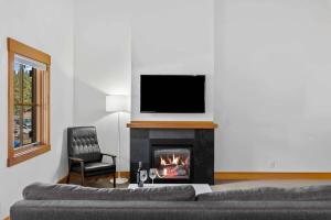 a living room with a fireplace with a television above it at Front Street Suites - Pacific Retreats in Leavenworth +35 photos