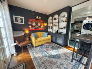 a living room with a yellow chair and a couch at Capitol Hill Carriage House in Washington, D.C.