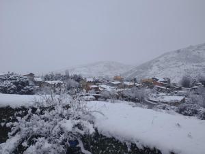 a small town covered in snow with houses at Winahost Casita Sierra de Madrid in Las Herreras