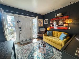 a living room with a yellow couch and a painting at Capitol Hill Carriage House in Washington, D.C.