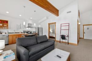 a living room with a couch and a kitchen at Annapurna - Alice Lodging in Leavenworth
