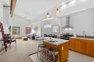 a kitchen and living room with a counter and stools at Klonaqua - Pacific Retreats in Leavenworth +26 photos