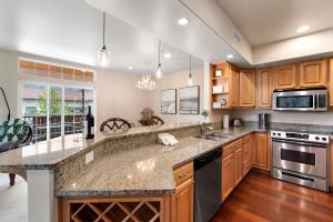 a kitchen with wooden cabinets and a granite counter top at Apres Ski Chalet - Pacific Retreats in Leavenworth