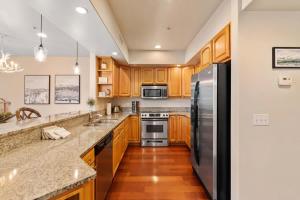 a kitchen with wooden cabinets and a stainless steel refrigerator at Apres Ski Chalet - Pacific Retreats in Leavenworth +23 photos