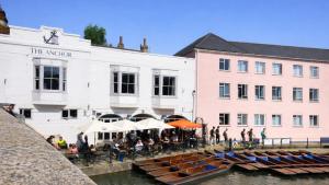 a group of people sitting at tables near boats in the water at AMETHYST - 4br all with ensuite & parking in Cambridge