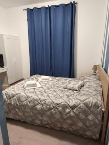 ein Schlafzimmer mit einem Bett und einem blauen Vorhang in der Unterkunft None Holiday Hotel in None
