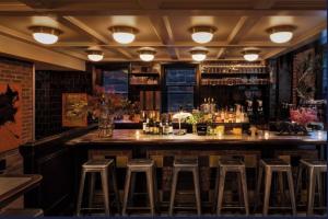 a bar with stools in a room with a counter at The High Line Hotel in New York +16 photos