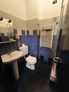 Ein blau gefliestes Badezimmer mit Toilette und Waschbecken in der Unterkunft None Holiday Hotel in None