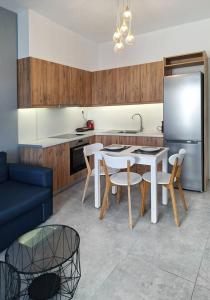 a kitchen with a table and chairs and a refrigerator at Blue wave in Ierapetra