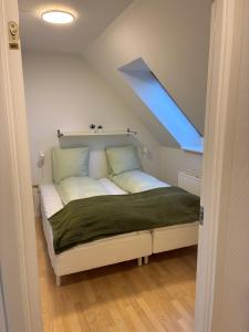 a bed in a small room with a skylight at Gammel Løgten Strandkro in Hornslet +33 photos
