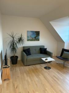 a living room with a green couch and a table at Gammel Løgten Strandkro in Hornslet