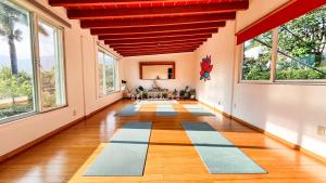 a hallway with large windows and a room with mats on the floor at Refugio del Colibrí in Tepoztlán