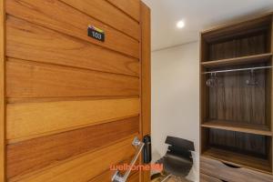 a wooden door with a sign on it in a room at Apartamento no tradicional Bairro do Bixiga em SP in São Paulo