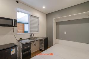 a kitchen with a sink and a microwave in a room at Apartamento no tradicional Bairro do Bixiga em SP in São Paulo