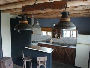 a kitchen with three lights hanging from the ceiling at Cabaña Kokopelli in Villa Giardino