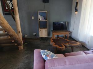 a living room with a couch and a table at Cabaña Kokopelli in Villa Giardino