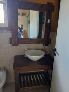 a bathroom with a bowl sink and a mirror at Cabaña Kokopelli in Villa Giardino +16 photos