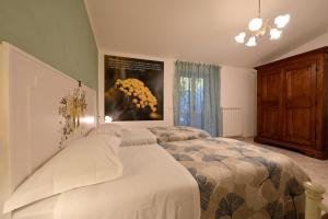 a bedroom with two beds and a painting on the wall at Domus Aromatica in Assisi