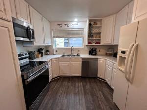 a kitchen with white cabinets and black appliances at Sunny Days! Room for All and Pet Friendly in Pocatello