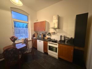 a kitchen with wooden cabinets and a table and a window at Ferienwohnung Margrit in Börßum