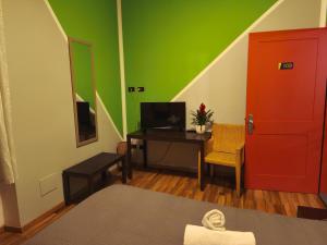Ein Zimmer mit einem Schreibtisch, einer roten Tür und grünen Wänden in der Unterkunft None Holiday Hotel in None