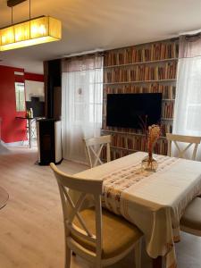 a dining room with a table and a tv at Logis Hôtels Restaurant Les 3 Rois in Issoudun