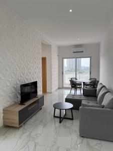 a living room with a couch and a tv at AQUÁRIO Apart Hotel in Sal Rei