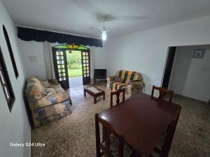a living room with couches and a table and a dining room at Família Marques in Itanhaém