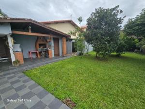 a house with a lawn in front of it at Família Marques in Itanhaém