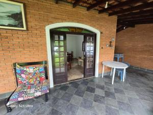a patio with a table and a chair next to a brick wall at Família Marques in Itanhaém +1 photo