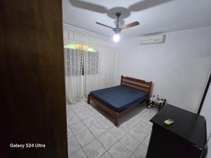 a bedroom with a bed and a ceiling fan at Família Marques in Itanhaém