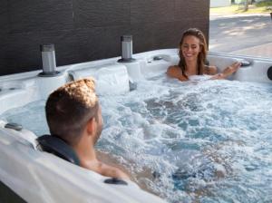 a man and a woman in a hot tub at ROYAL Villa RESORT & SPA - Jacuzzi, Sauna, MELEX na plażę, Masaże, Apartamenty z kuchnią, Widok na Zalew Wiślany in Krynica Morska