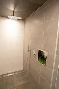 a bathroom with a shower with green bottles at BenB Tuskendepade in Oldeholtpade
