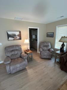 a living room with two chairs and a couch and a lamp at KSK Getaway in Nekoosa