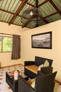 a living room with a couch and chairs and a chandelier at Hotel Altocerro in Constanza