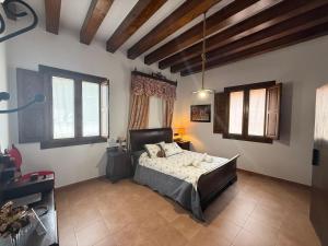 a bedroom with a bed and two windows at La Casa de la botica -Casa Rural El Romeral de Toledo in Romeral