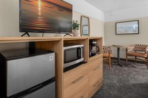 a living room with a television and a kitchen with a table at Looking Glass Inn in Lincoln City