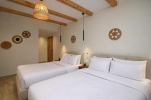 two beds in a room with white walls and wooden ceilings at Pyramids Height Luxury Wing in Cairo