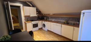 a small kitchen with white cabinets and a sink at Central Stay Odda in Odda