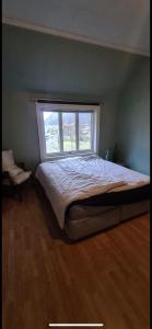 a bedroom with a large bed with a window at Central Stay Odda in Odda