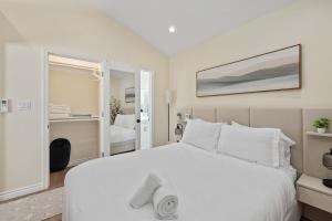 a bedroom with a large white bed and a mirror at Luxury 1BR Suite Kitchen, Fireplace, Laundry, BBQ in Simi Valley