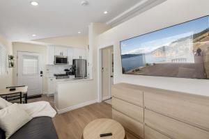 a living room with a large flat screen tv on a wall at Luxury 1BR Suite Kitchen, Fireplace, Laundry, BBQ in Simi Valley