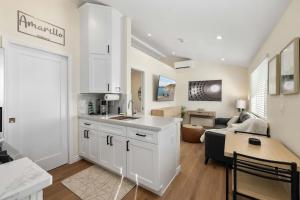 a kitchen with white cabinets and a living room at Luxury 1BR Suite Kitchen, Fireplace, Laundry, BBQ in Simi Valley +13 photos