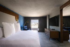 a hotel room with a large bed and a television at Bally's Baton Rouge Hotel in Baton Rouge +12 photos