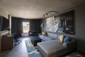 a living room with a couch and a desk at Bally's Baton Rouge Hotel in Baton Rouge