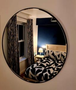 a mirror reflecting a bedroom with a bed and a window at Seaglass, The Bay - Filey Ground Floor Step Free Easy Access and Parking in Filey +2 photos