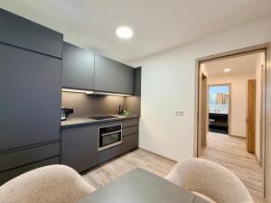 a kitchen with gray cabinets and a table and chairs at GG Apartment 7 in Garmisch-Partenkirchen