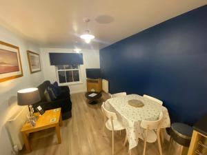 a living room with a table and a blue wall at Seaglass, The Bay - Filey Ground Floor Step Free Easy Access and Parking in Filey