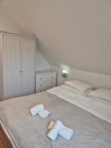 a bedroom with two towels on a bed at Tündérkert Tündérfészek Vendégház in Sződliget