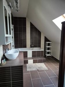 a bathroom with a sink and a bath tub at Tündérkert Tündérfészek Vendégház in Sződliget